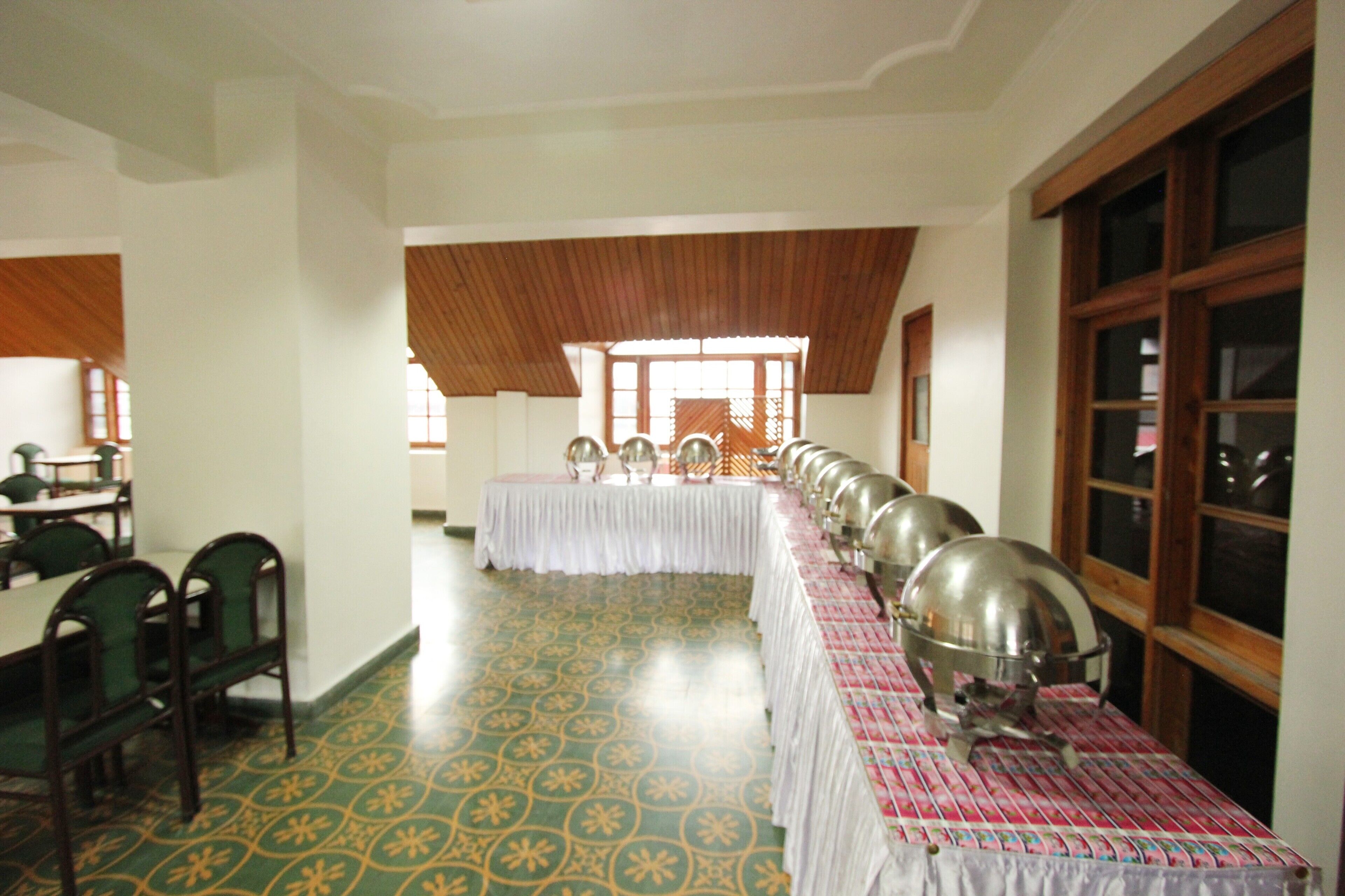 A dining hall with long tables, chairs, and a patterned floor.