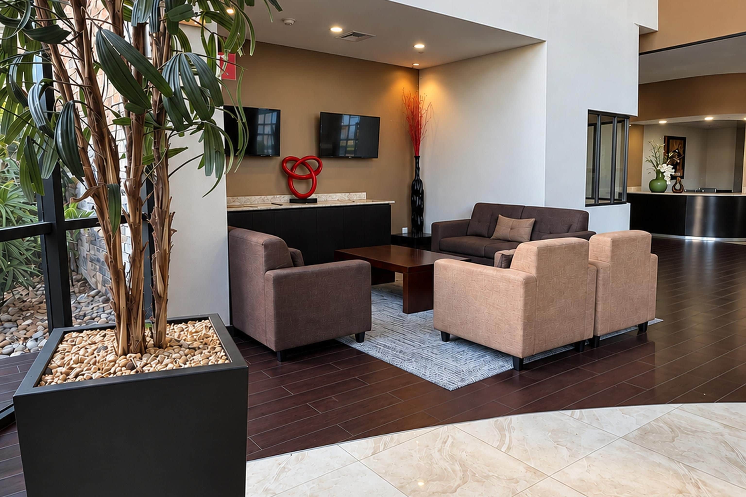 A modern lobby with a seating area, a reception desk, and a large window.
