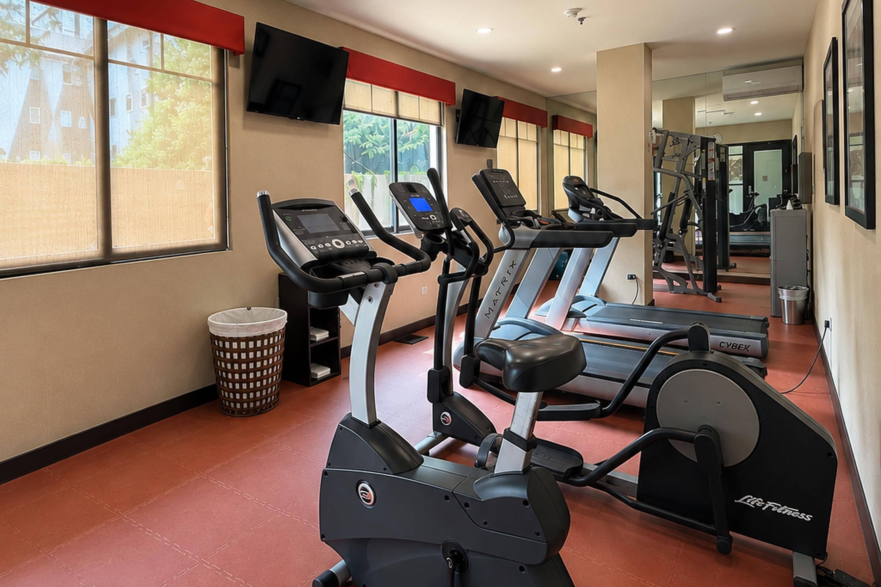A gym with treadmills, an elliptical, and a stationary bike.