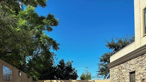 Una piscina con un muro de piedra y una banca.
