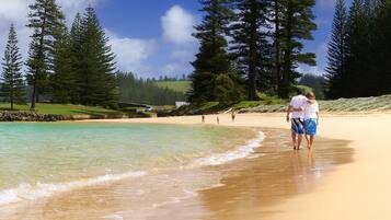 Enjoy a tranquil beach experience with turquoise waters and lush surroundings.