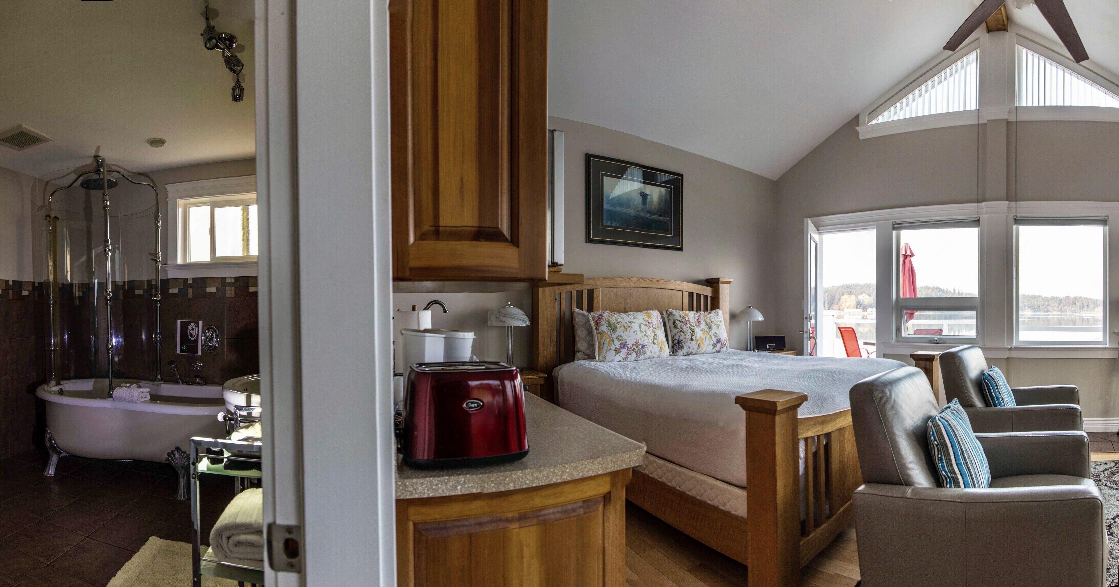 Une chambre à coucher avec un lit, une tête de lit en bois, une fenêtre et une vue sur l’extérieur.