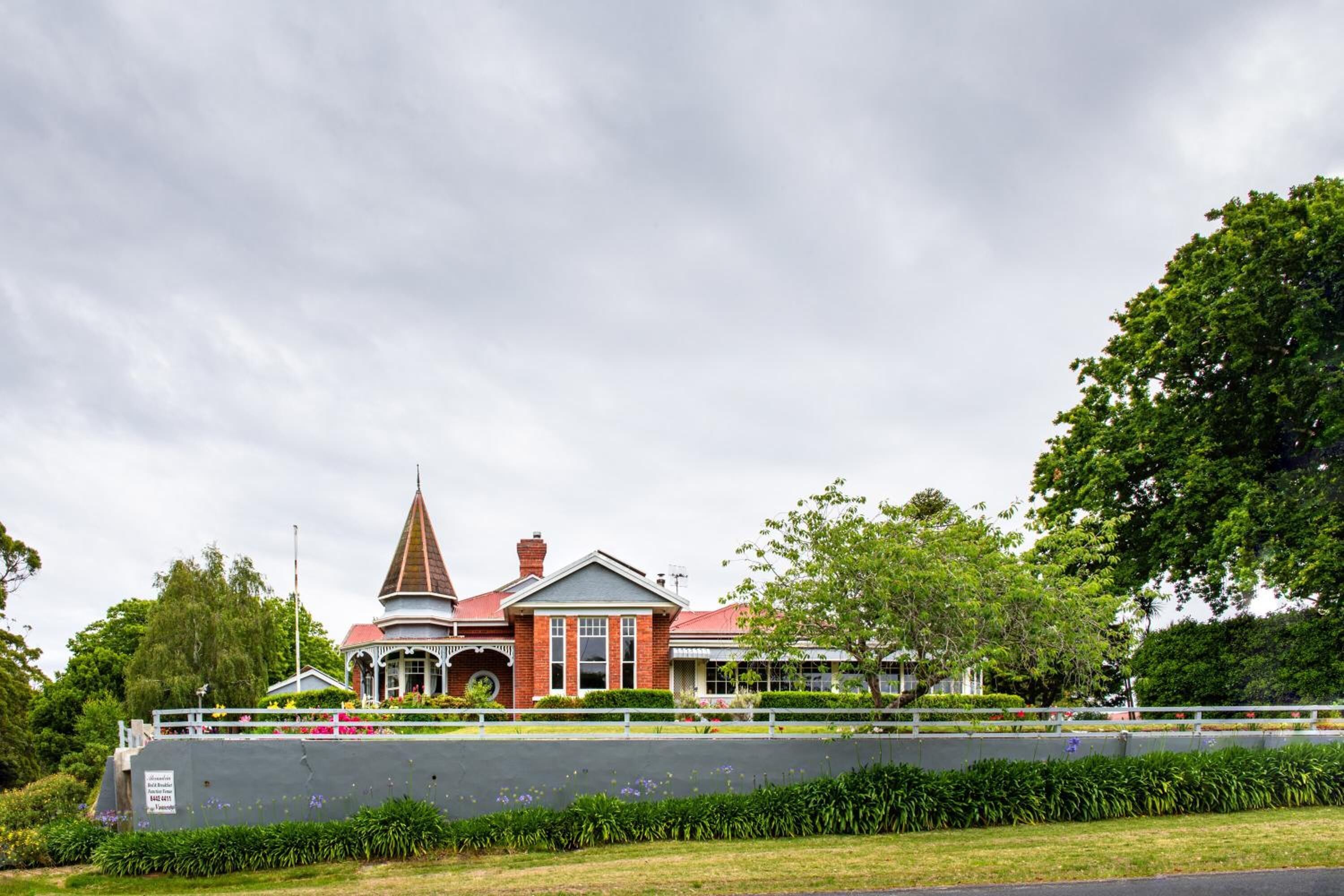 A historic building with a prominent tower, a covered porch, and a brick facade.