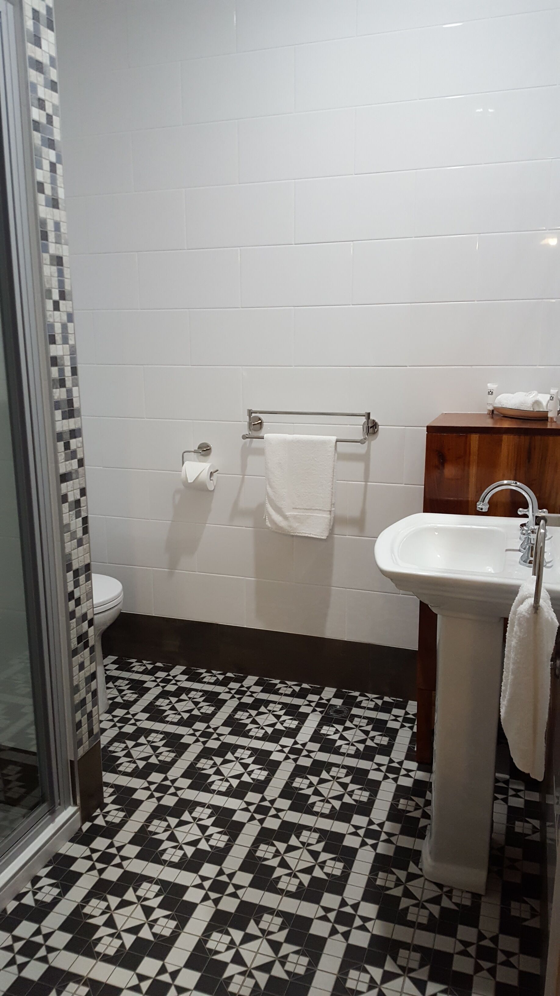 Un baño con inodoro blanco, lavabo y zona de ducha.