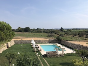 Una piscina al aire libre, sillones reclinables de piscina
