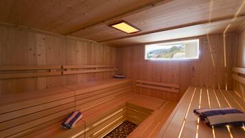 Una sauna de madera con bancos y una pequeña ventana.