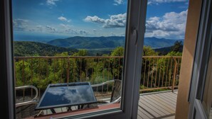 A balcony with a table and chairs, offering a view of a mountainous landscape. - L'Alexain Hôtel Restaurant & Wellness (Niedermorschwihr)