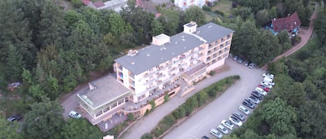 Ein Luftbild eines mehrstöckigen Hotels mit Parkplatz.