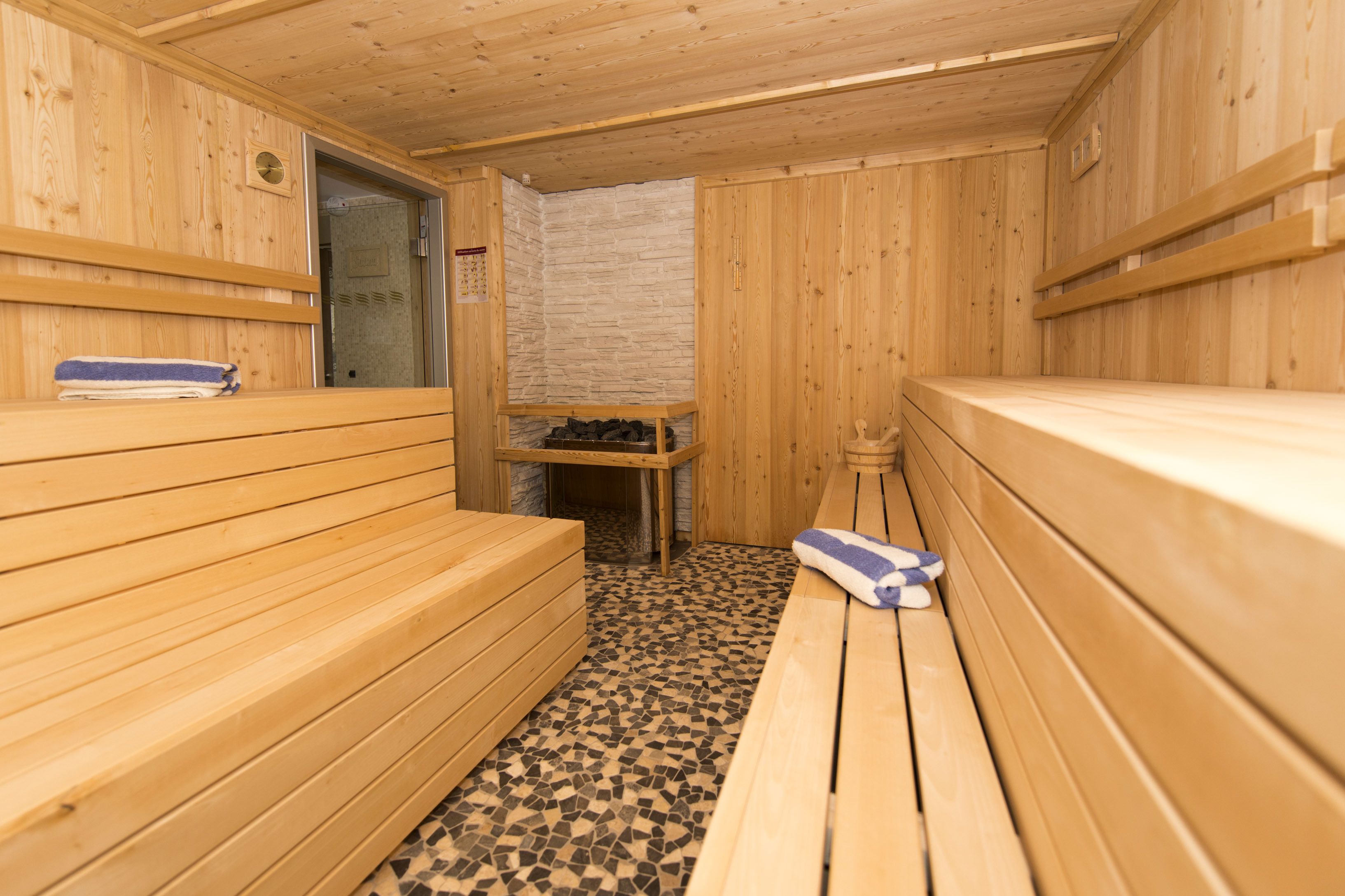 A sauna room with wooden benches and a tiled floor.