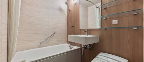 A modern bathroom with a bathtub, a sink, and a toilet.