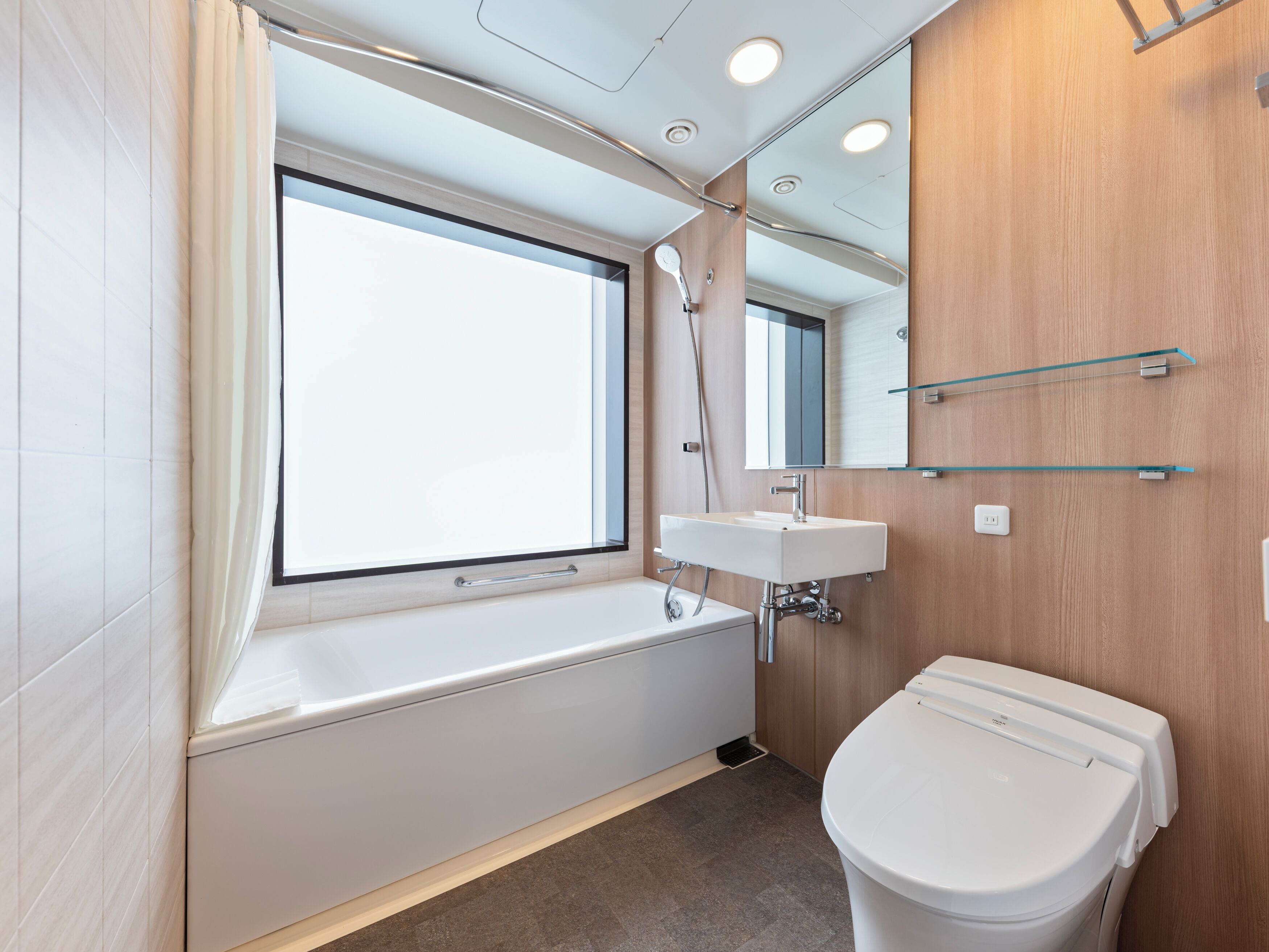 A modern bathroom with a bathtub, a sink, and a toilet.