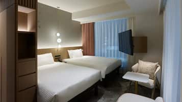 A hotel room with two beds, a desk, a chair, a TV, and a wardrobe.