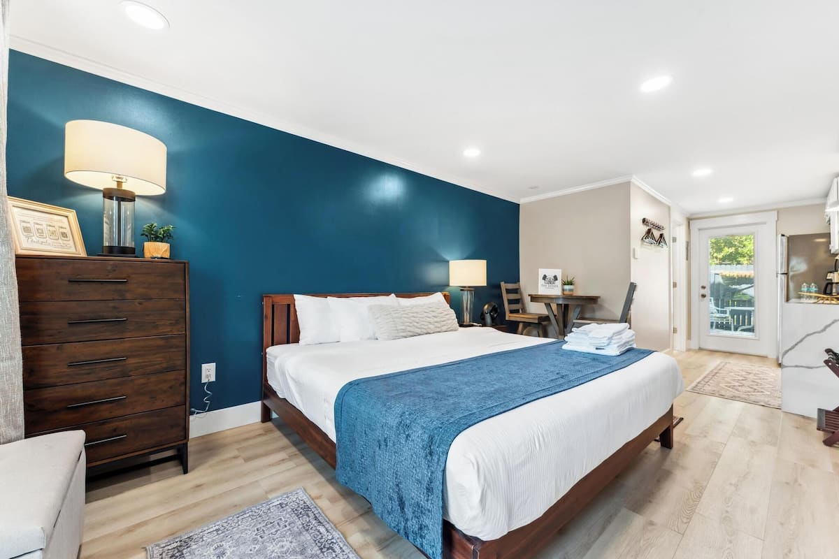 Ein Schlafzimmer mit Bett, Kommode, Schreibtisch und Stuhl.