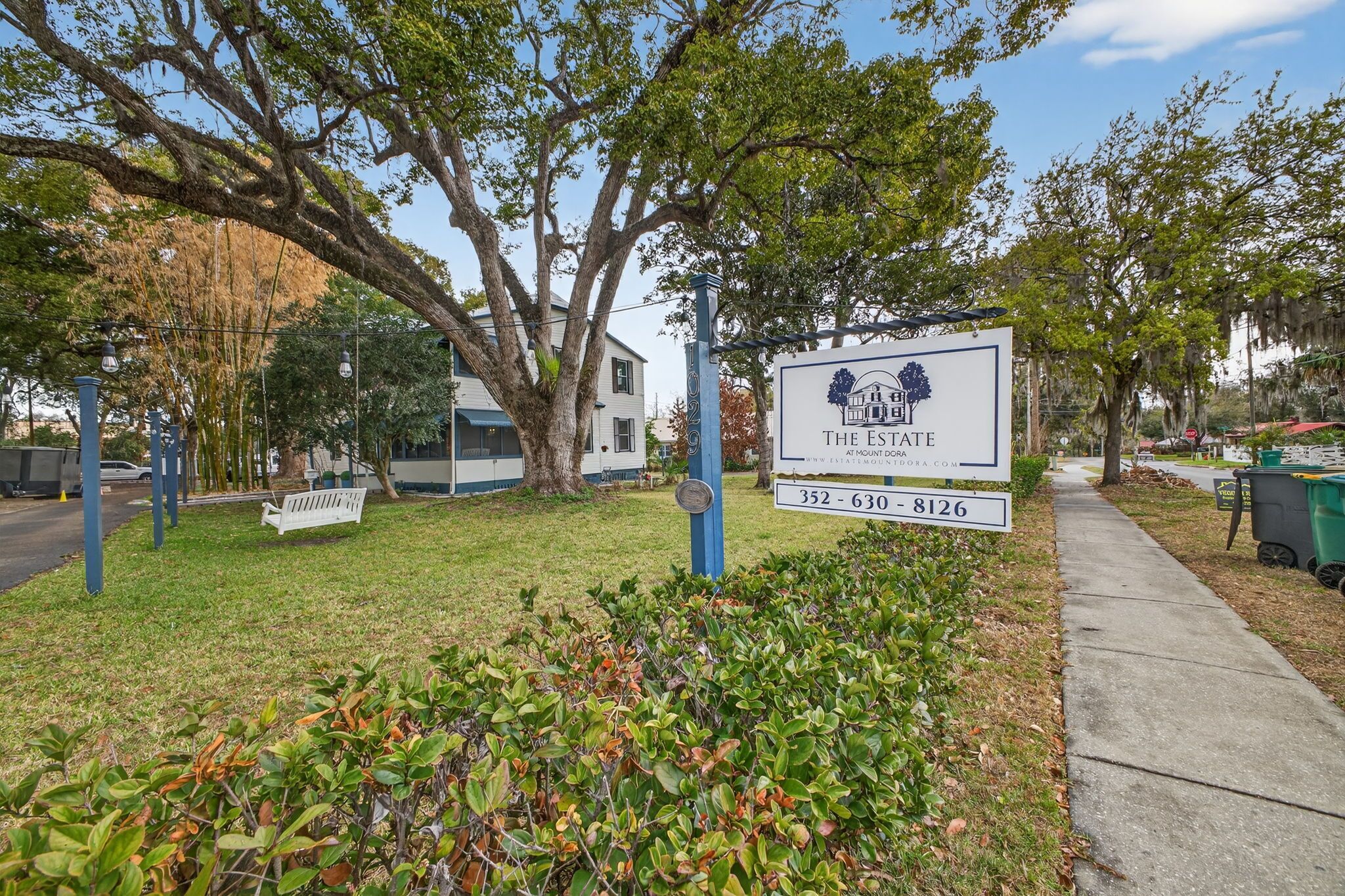 A sign for 'The Estate at Mount Dora' with contact numbers.