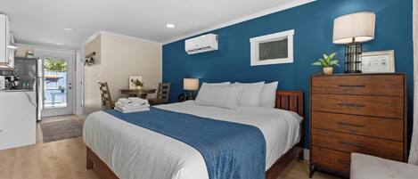 Quarto com cama, cômoda e escrivaninha com cadeira.
