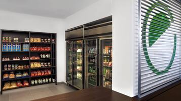 Un interior moderno con estante para aperitivos y vitrina refrigerada.