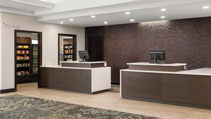 A reception area with two counters, a 'market' sign on the left, and a patterned carpet. - Residence Inn by Marriott Ottawa Airport (Ottawa)