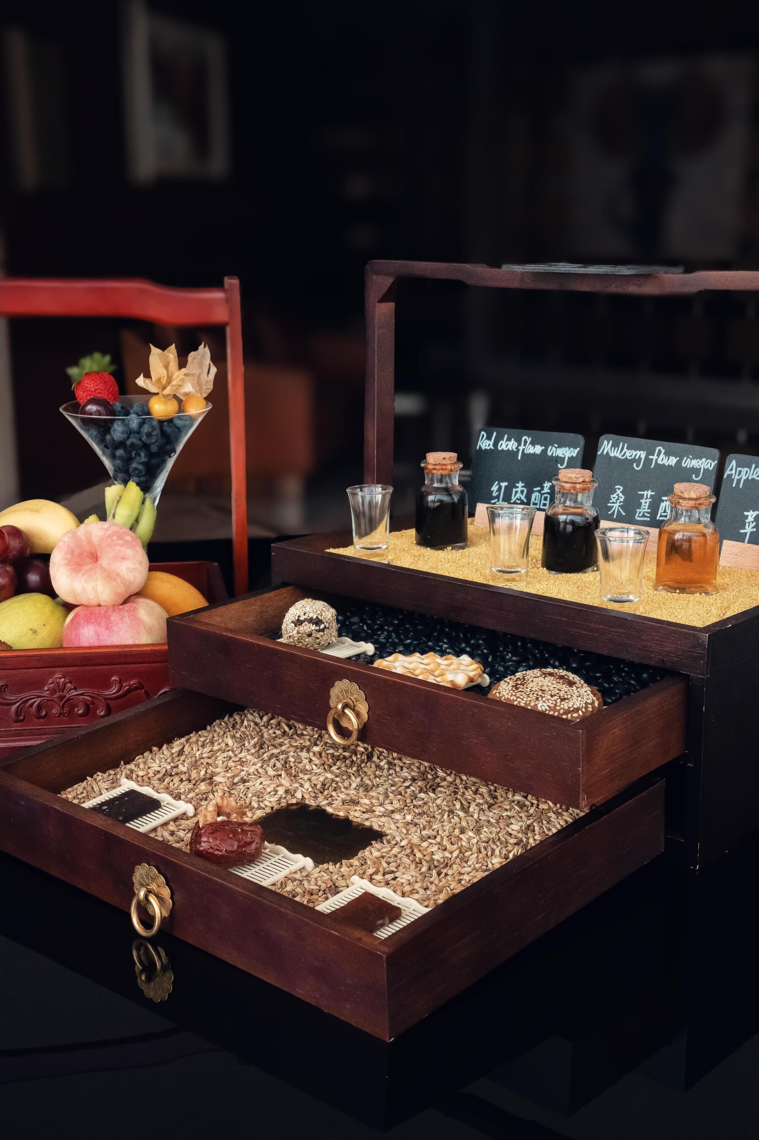 A display of various food items including fruits, nuts, and jars of sauces.