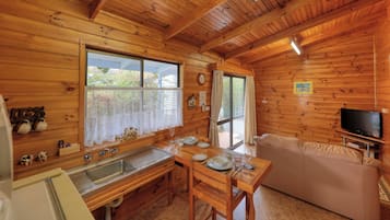 Deluxe-Ferienhaus, 1 Schlafzimmer, Gartenblick | Wohnbereich | 32-Zoll-Flachbildfernseher mit Digitalempfang, Fernseher