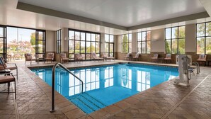 A swimming pool with clear blue water, surrounded by lounge chairs and a sunbed area. - Embassy Suites Chattanooga / Hamilton Place (Chattanooga)