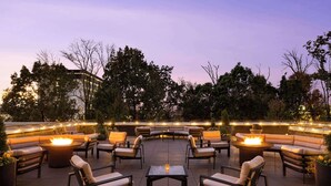 An outdoor patio area with a circular seating arrangement, fire pits, and ambient lighting. - Embassy Suites Chattanooga / Hamilton Place (Chattanooga)
