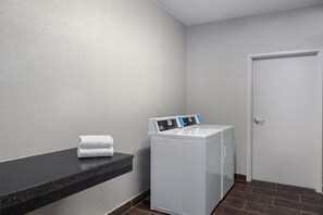 A laundry area with a washing machine and a towel on a counter. - Hampton Inn Cotulla (Cotulla)