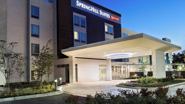 A modern hotel with a large entrance and a covered area. - SpringHill Suites Pensacola (Pensacola)