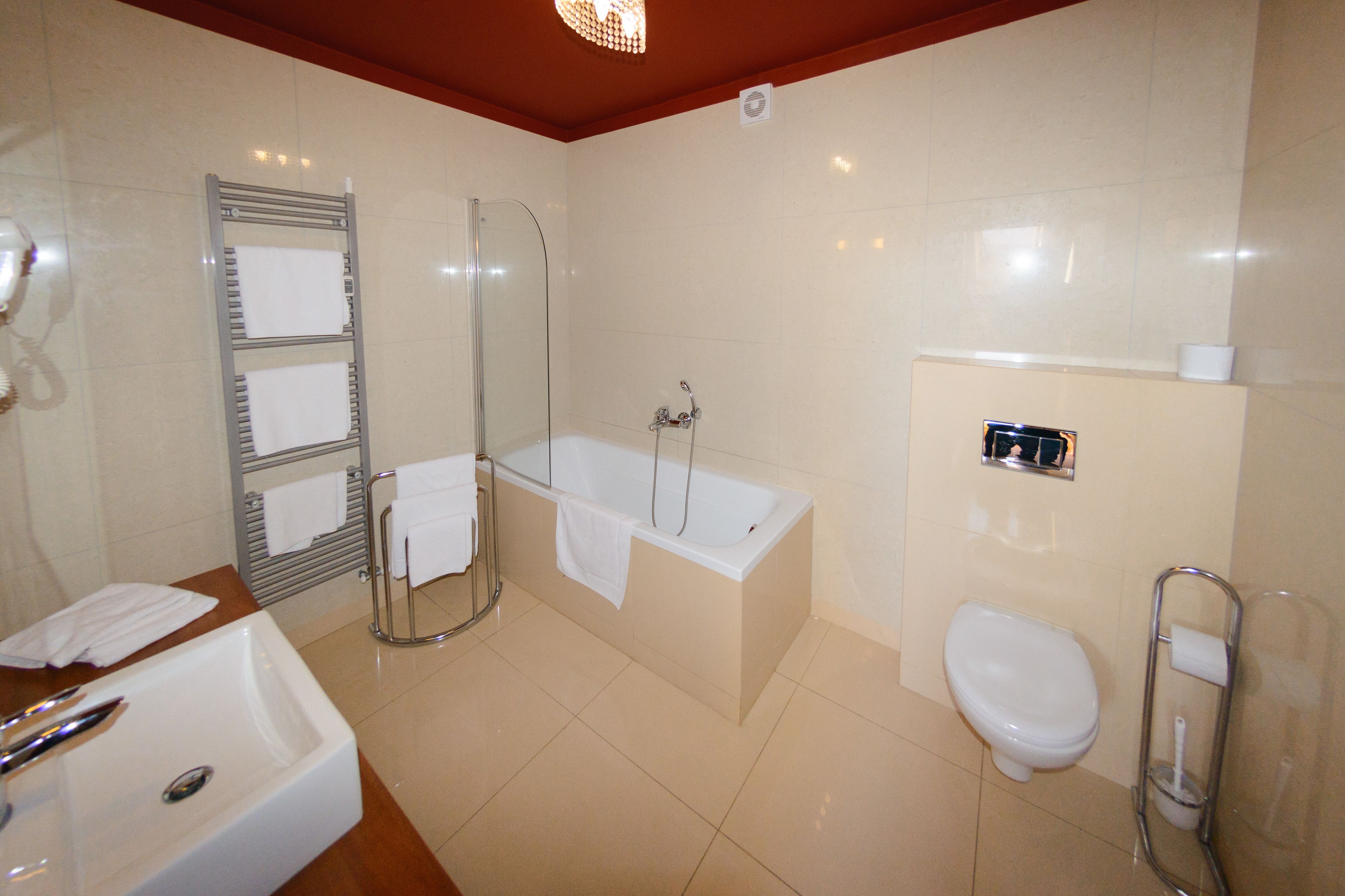 A bathroom with a sink, bathtub, toilet, and glass shower enclosure.