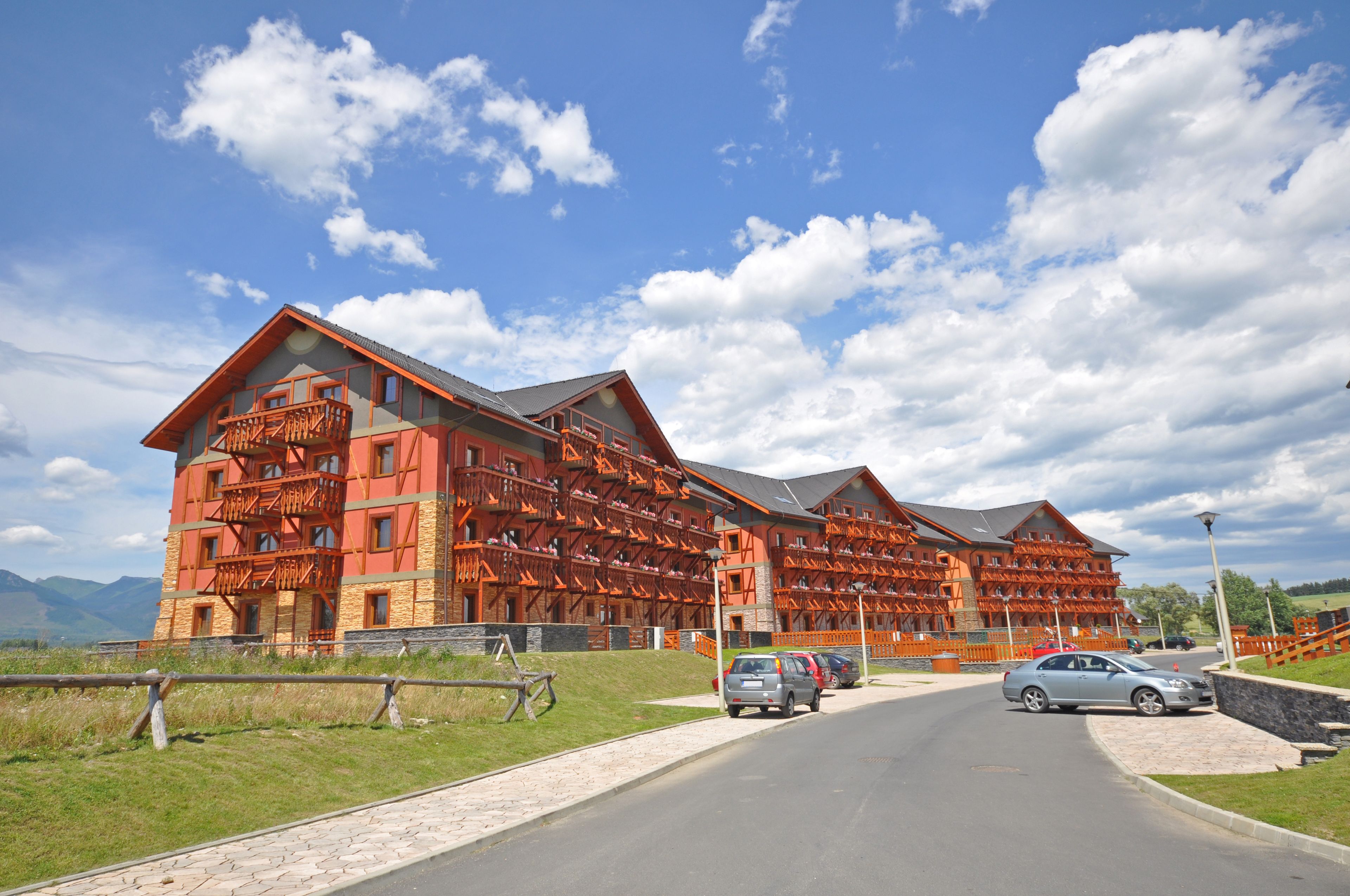 Et stort, flerlags hotel med en karakteristisk træfacade og flere balkoner.