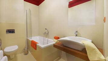 A bathroom with a bathtub, a sink, and a toilet.