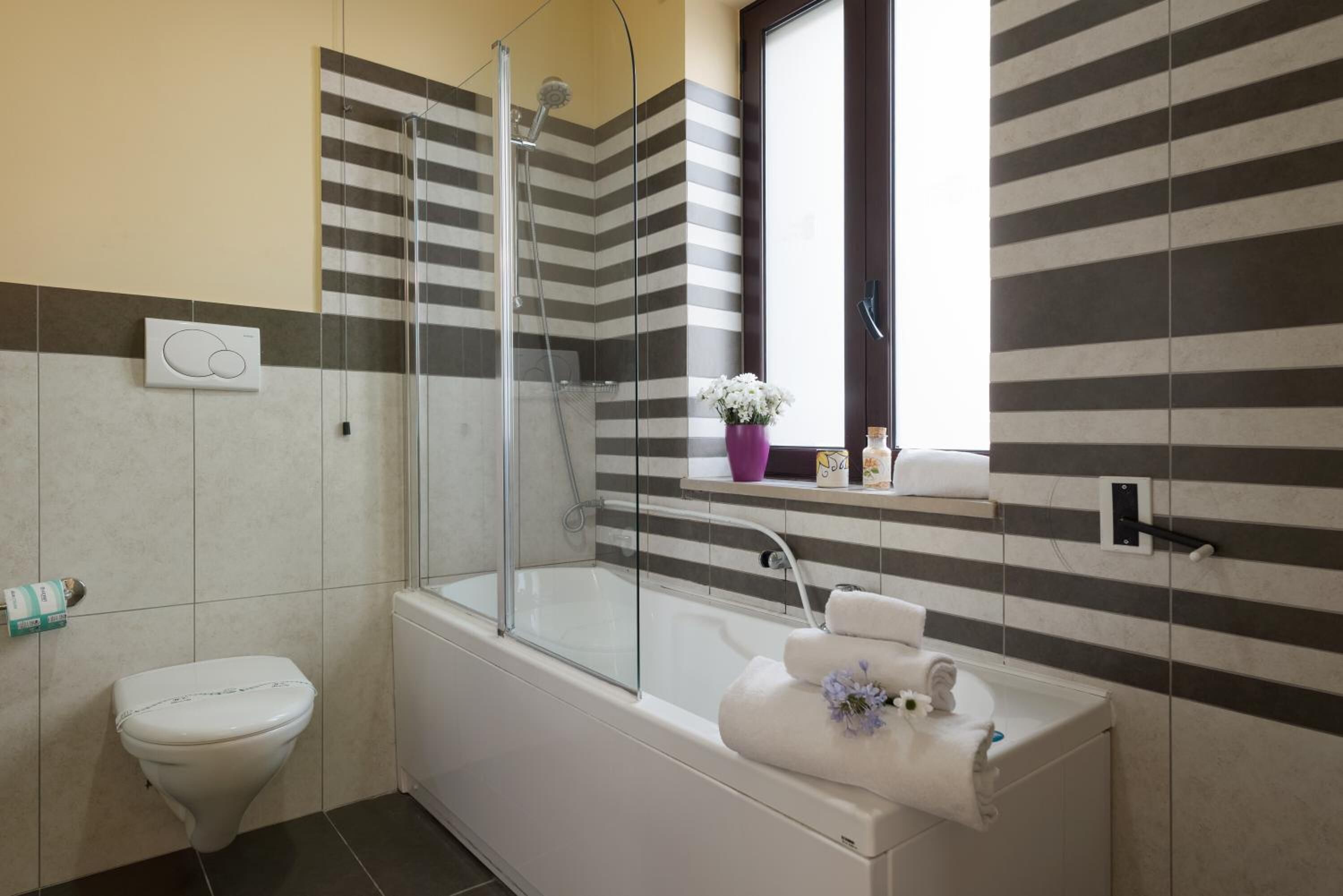 Une salle de bain avec douche, toilettes et lavabo.