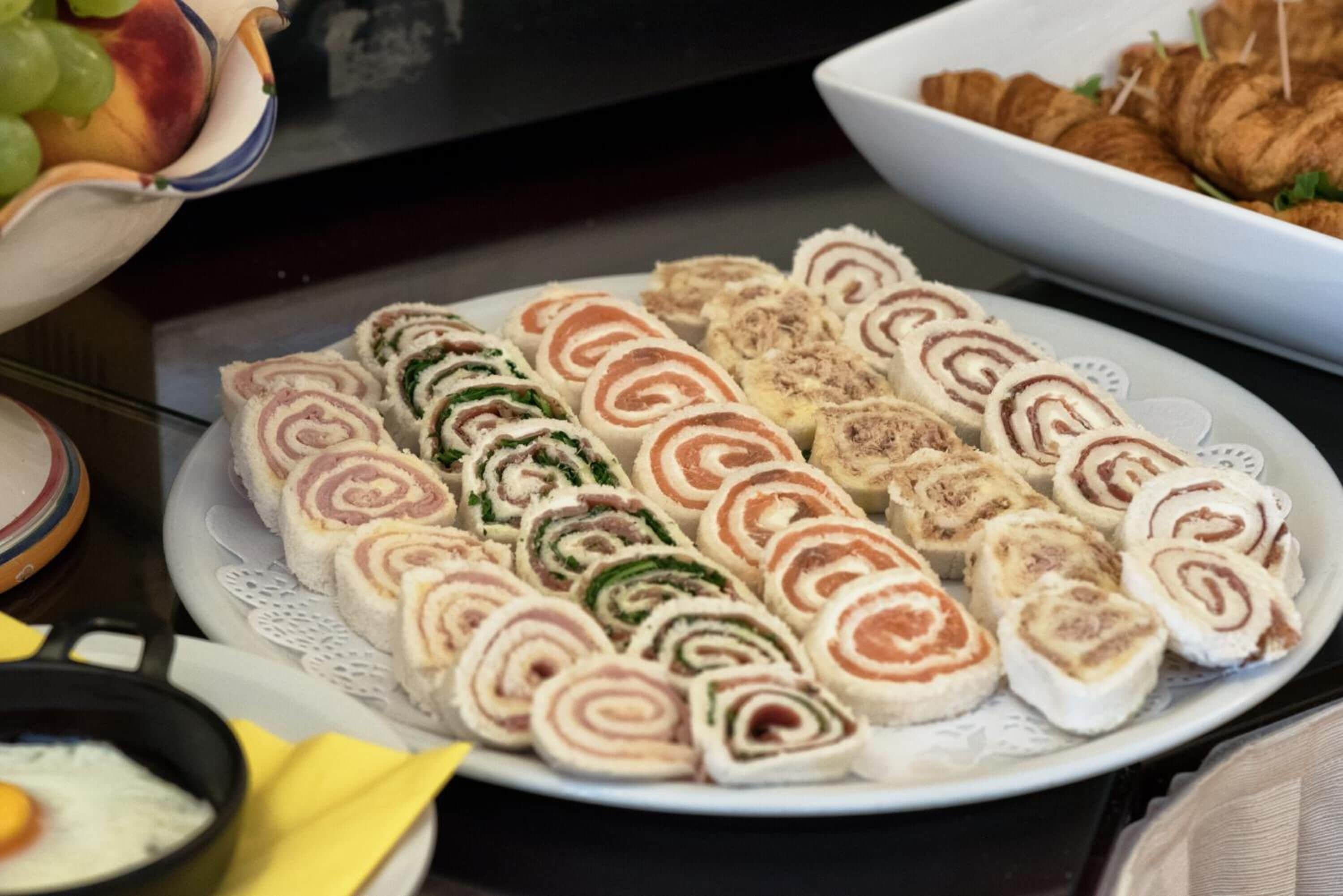 Une assiette de sandwichs roulés garnis de différentes préparations.