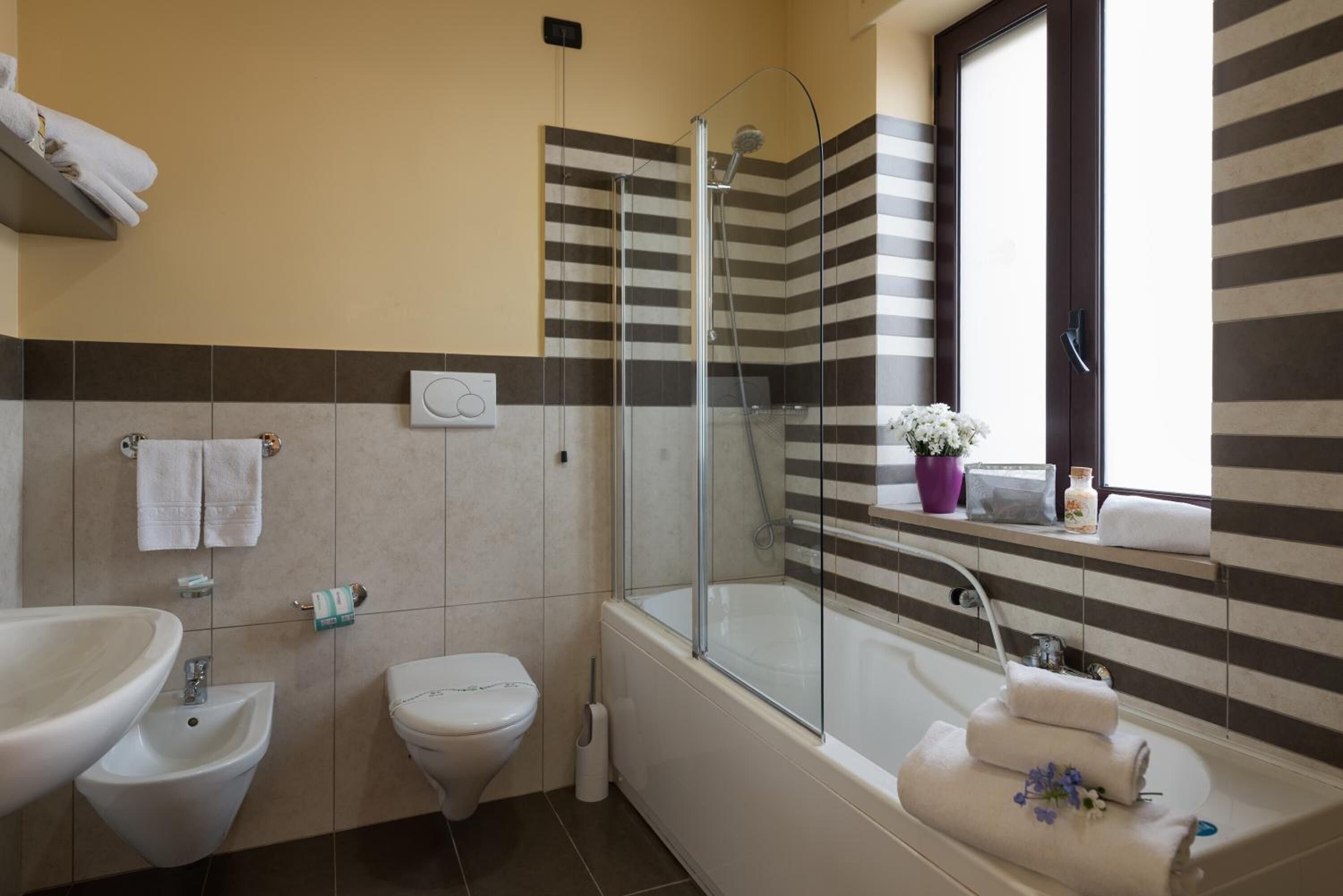 A bathroom with a bathtub, a shower, a sink, and a toilet.