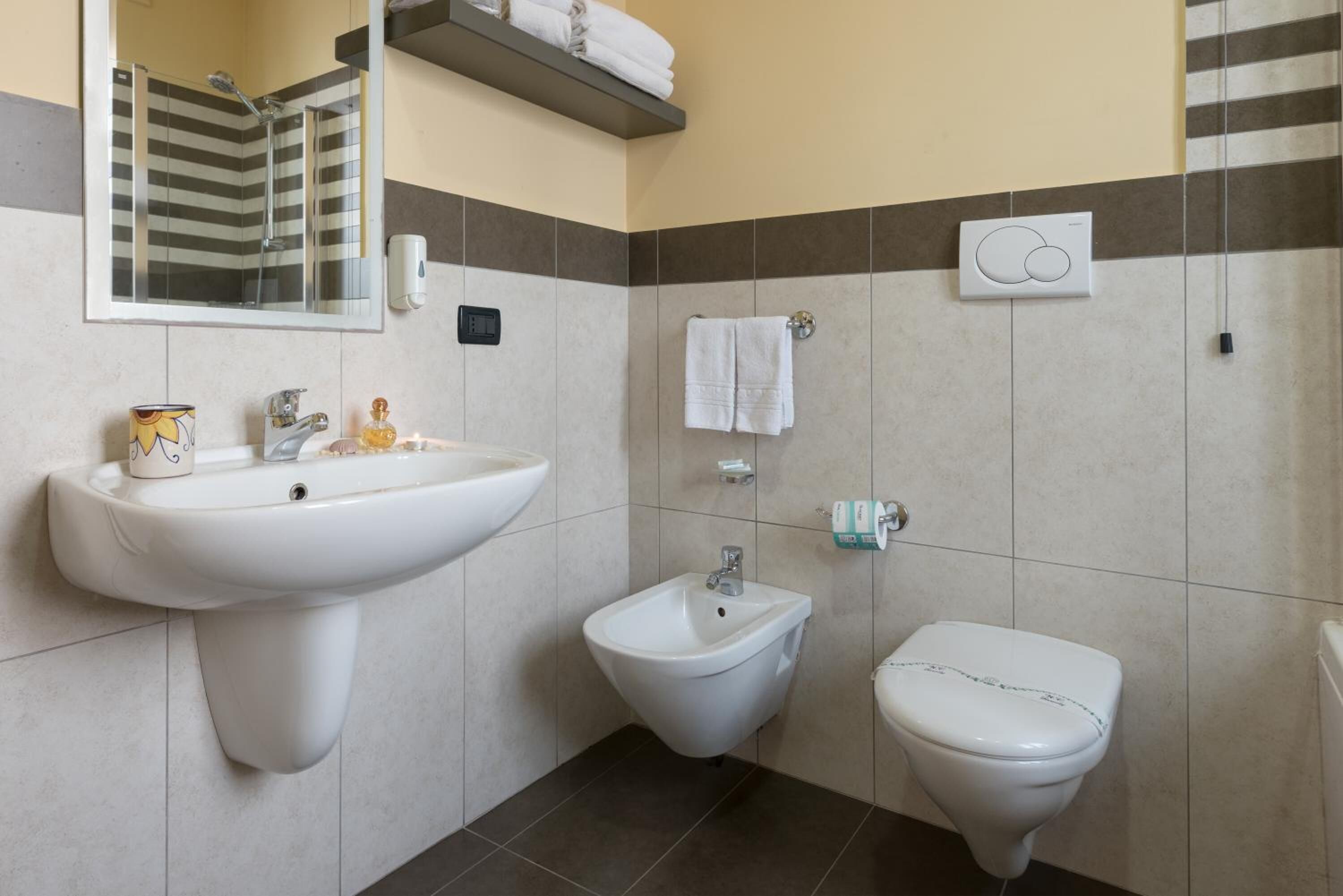 A bathroom with a sink, bidet, and toilet.