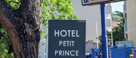 Señal de hotel que indica 'HOTEL PETIT PRINCE' con una flecha direccional.