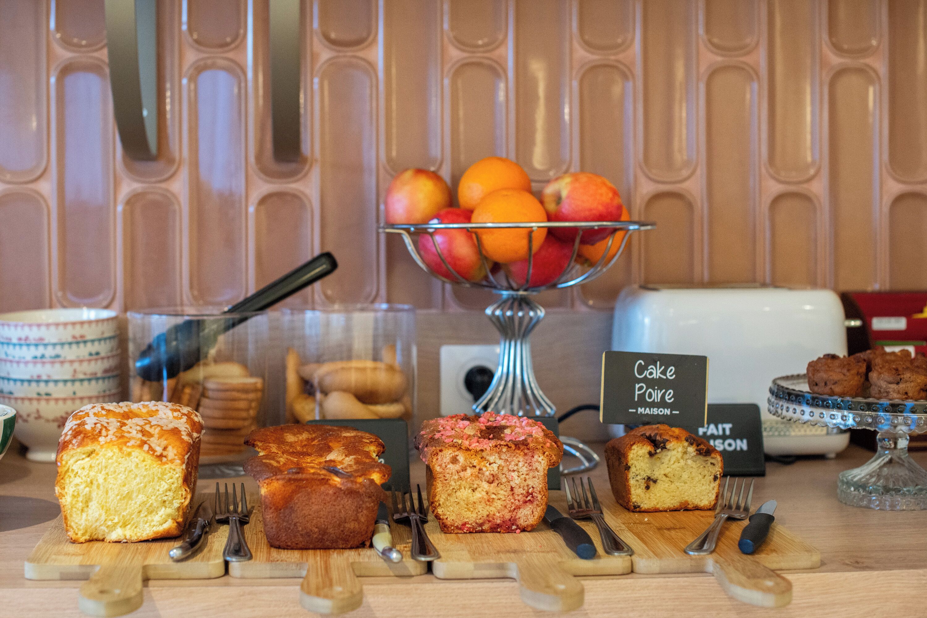 A bakery display with various baked goods and a fruit bowl.