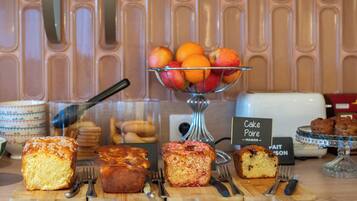 A bakery display with various baked goods and a fruit bowl.