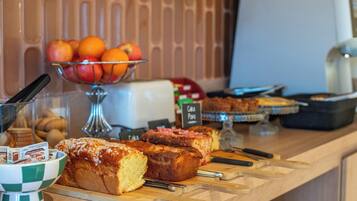 Een ontbijtbuffet met diverse gebakjes en fruit.