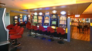 A casino with slot machines and red bar stools. - The Bridge (Smithton)