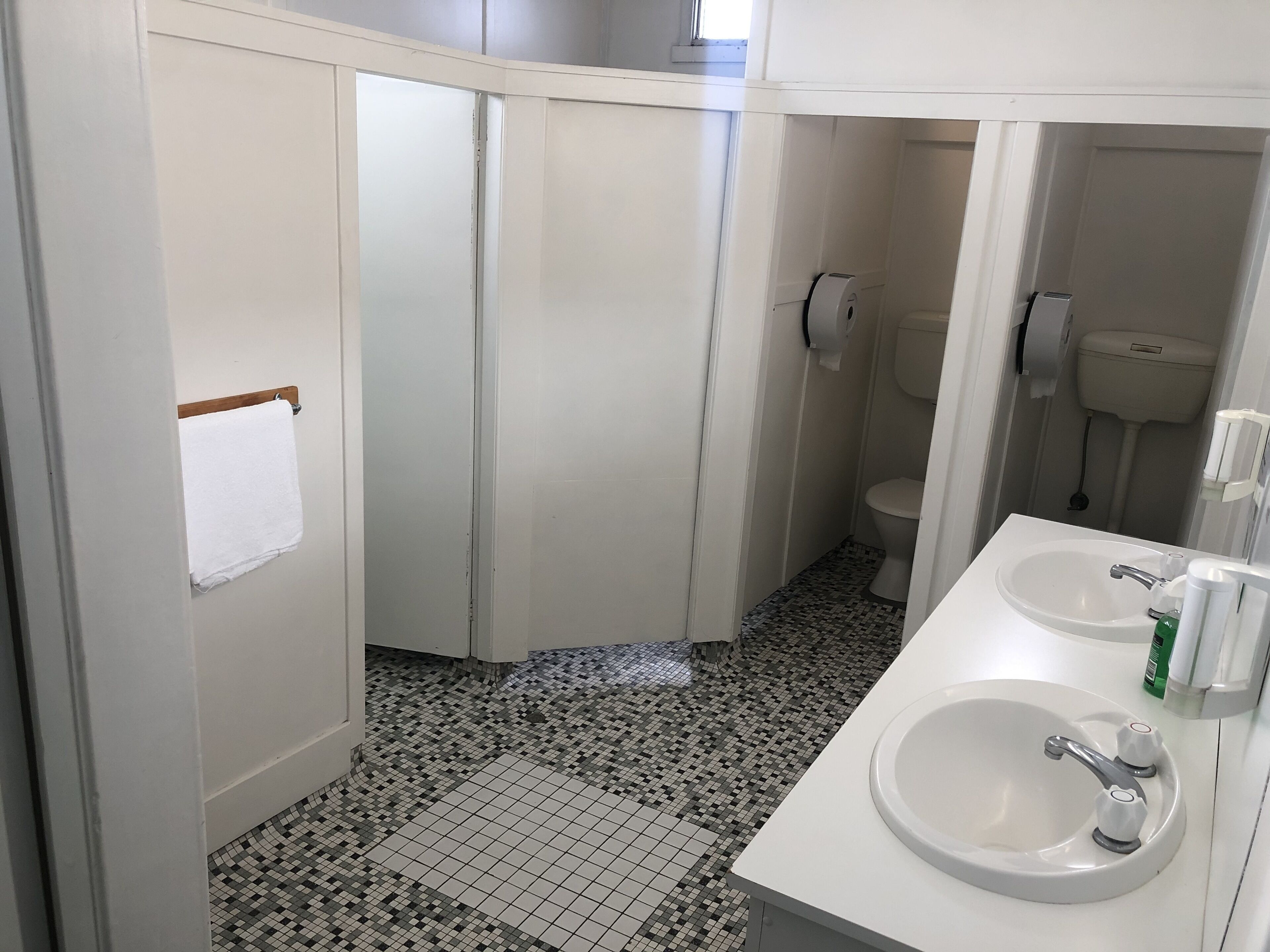 A bathroom with a white sink, toilet, and shower area.