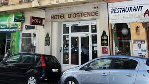Un hotel con fachada clásica, varias ventanas con contraventanas y un letrero que indica que es un hotel.