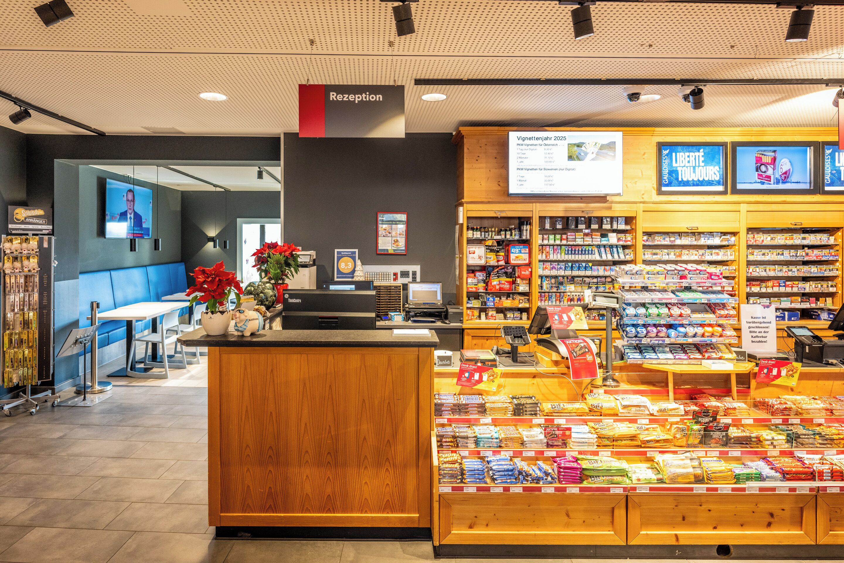 A reception area with a wooden counter, a TV screen, and a sign indicating 'Reception'.