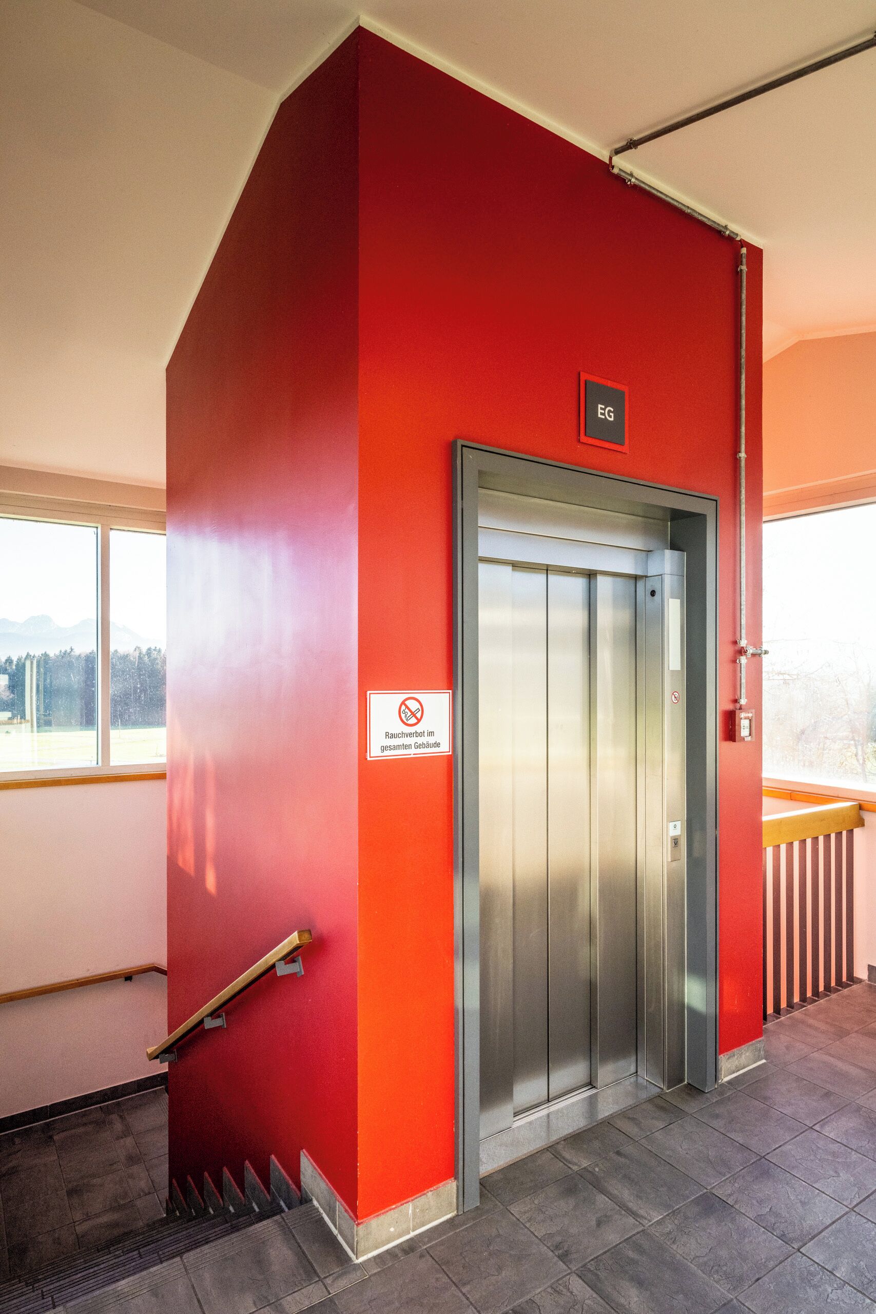 Un ascensor con pared roja y un letrero que indica que es un ascensor de incendios.