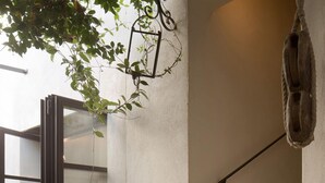 Un escalier avec une rampe en métal, une plante en pot et une statue de cheval.