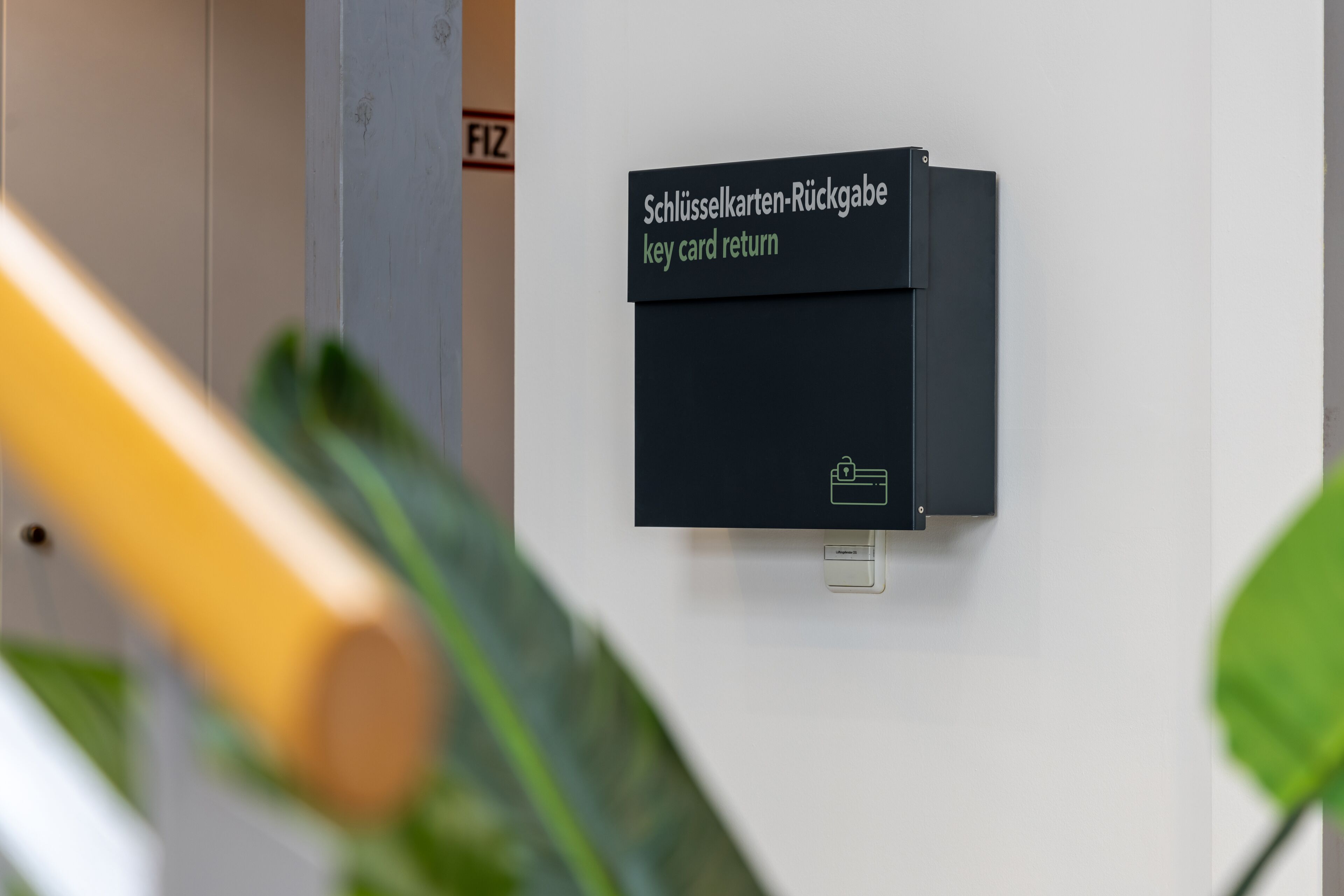 Un punto de devolución de tarjetas electrónicas en la pared, con una etiqueta en alemán.