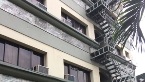 Um hotel com fachada verde, uma escadaria visível e uma placa com a inscrição "Golden Valley Hotel".