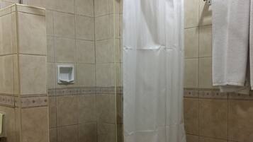 Une salle de bain avec une douche, des toilettes et un porte-serviettes.