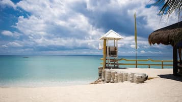 On the beach, white sand, sun loungers, beach umbrellas