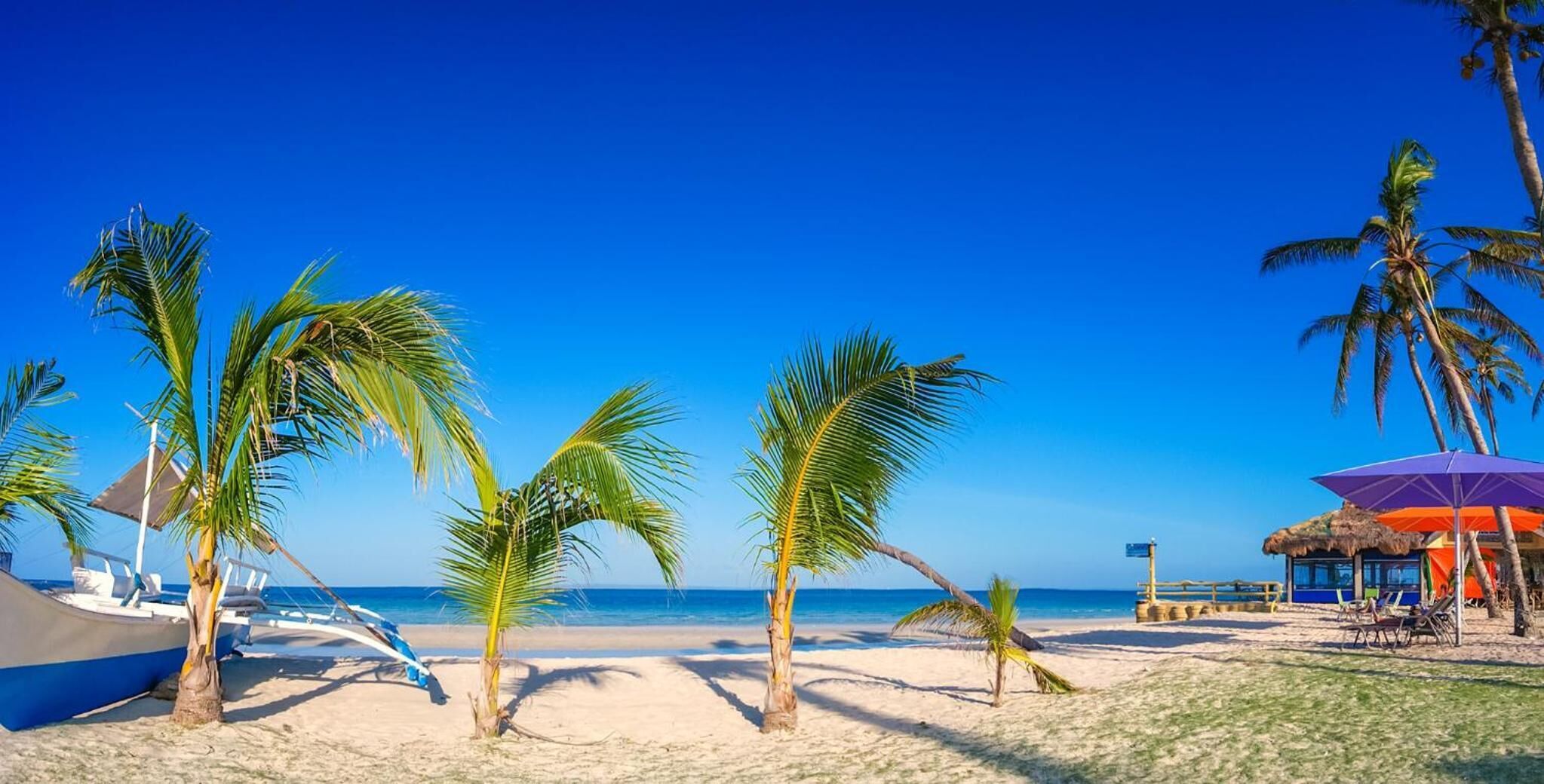On the beach, white sand, sun loungers, beach umbrellas