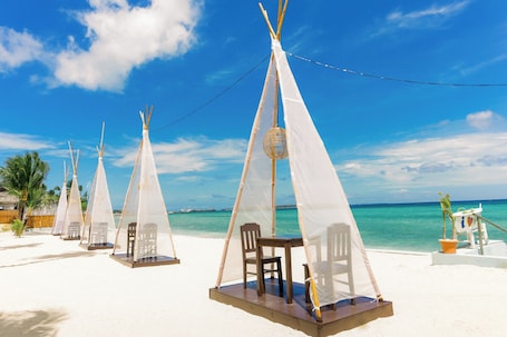 En la playa, arena blanca, sillas reclinables de playa, sombrillas